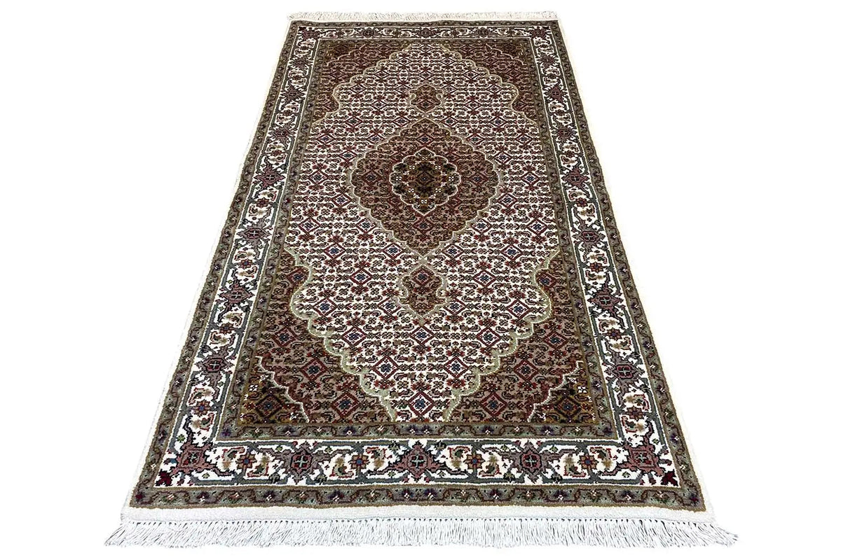 Indo Tabriz rug: narrow rectangular rug with medallion and ornamental border.