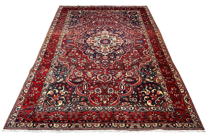 Red floral rug with a dark pattern and a wide decorative border