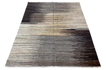 Kilim rug, trapezoidal with gray and beige stripes as well as dark areas.