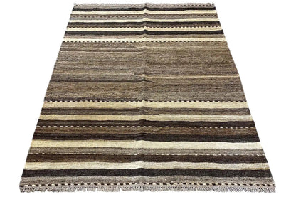 Draped rug with stripes in gray, beige and dark brown, fringes.