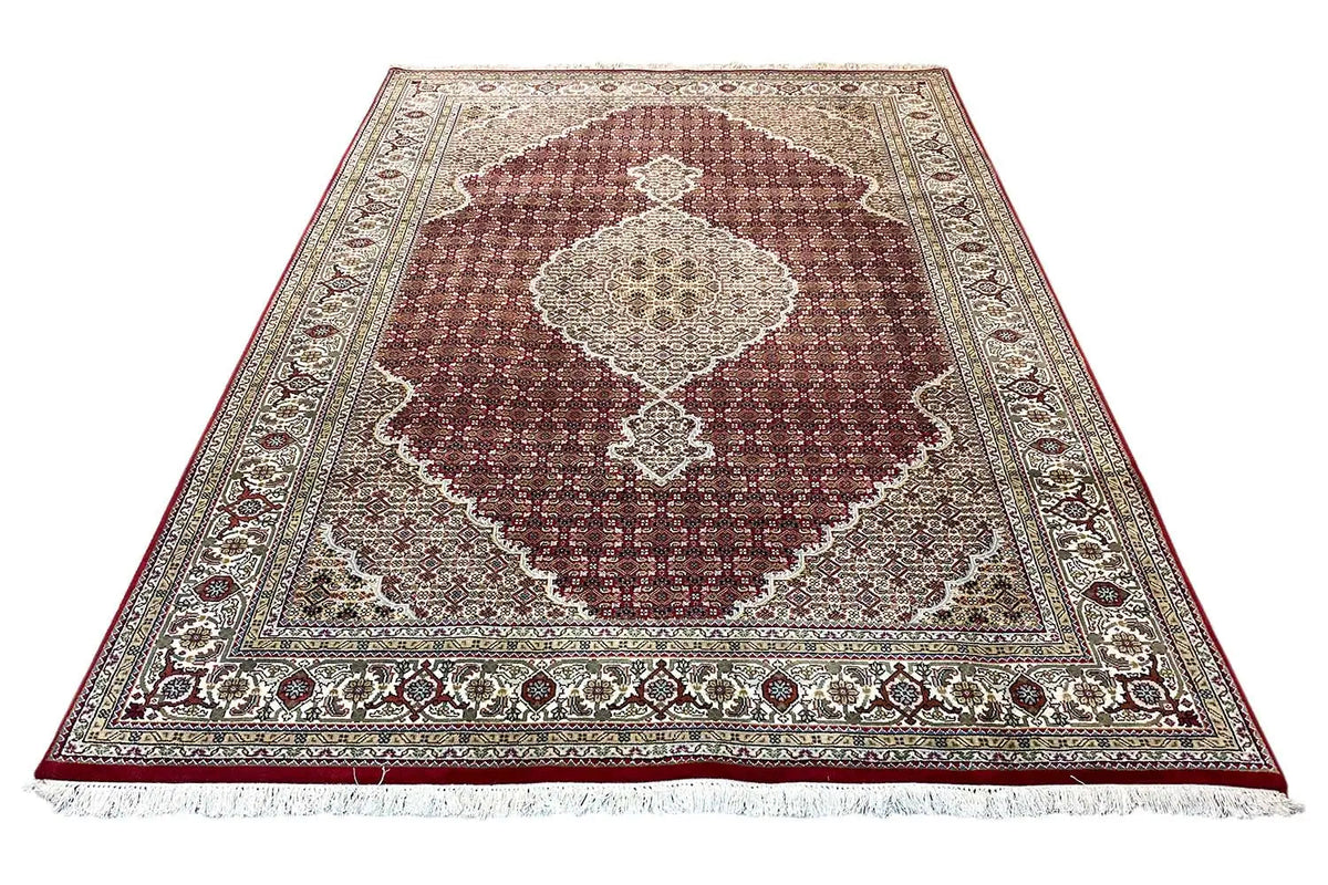 Rug with a maroon central medallion, beige background, and decorative border.