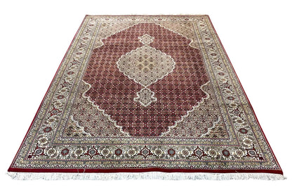 Rug with a maroon central medallion, beige background, and decorative border.