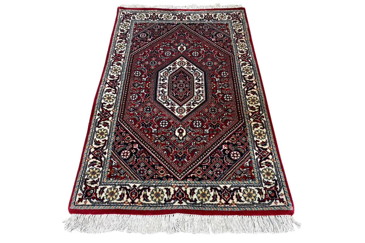 Rug (92x60 cm), red and blue, with a rectangular medallion, dark background, fringes