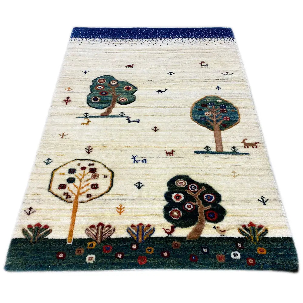 Gabbeh rug, cream-colored with a blue border and tree/animal motifs in the pattern