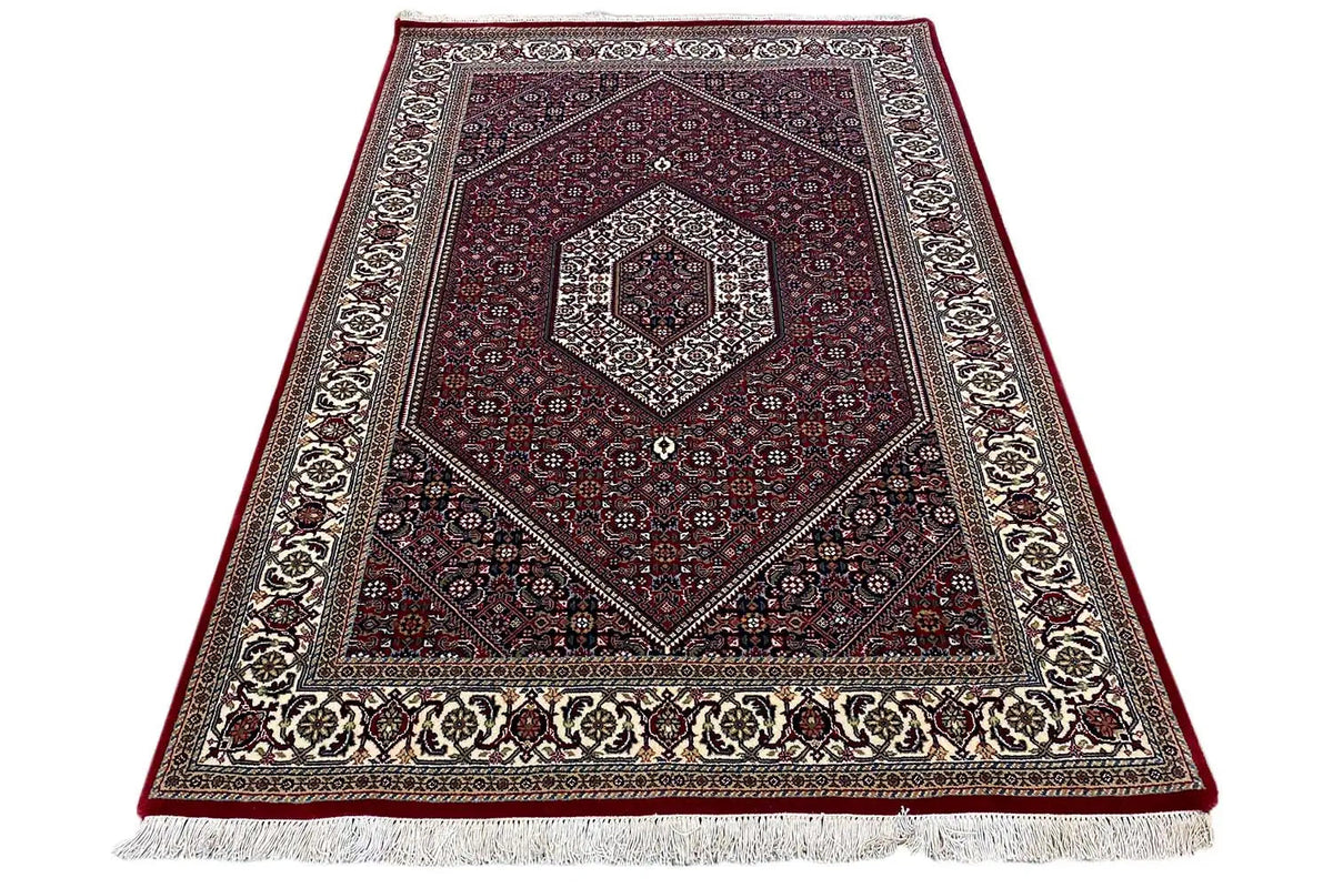 Oriental rug Bidjar, woven border and fringe along the lower edge; dark red with decorative stripes