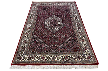 Oriental rug Bidjar, woven border and fringe along the lower edge; dark red with decorative stripes