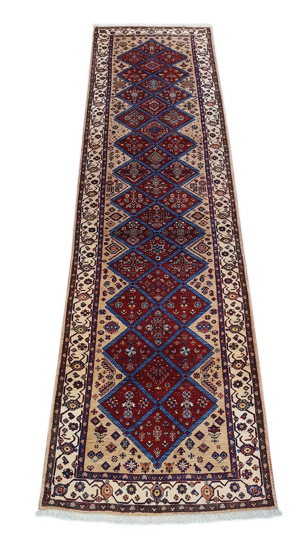 Oriental rug in a long runner format, with a border pattern in blue, red, and beige