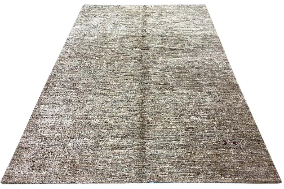 Gabbeh rug: large rug with mottled light beige-gray pile and a fine texture