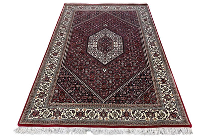 Bidjar rug folded/diagonally with fringes at the edge and a red patterned center