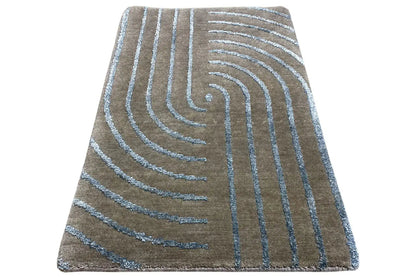 Designer rug with turquoise-blue swirling lines, spread out diagonally