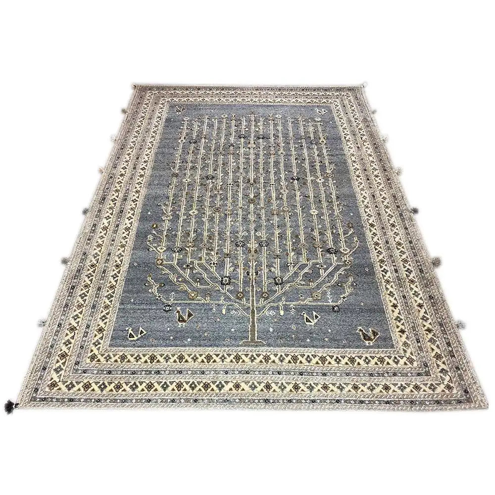 Rectangular blue-gray rug with a gold-colored tree and ornamental pattern