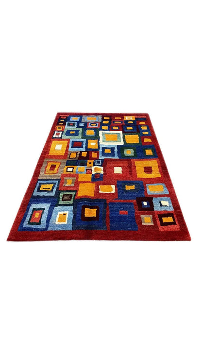 Gabbeh rug (200x151 cm) with square color blocks in blue, red, yellow, and white.