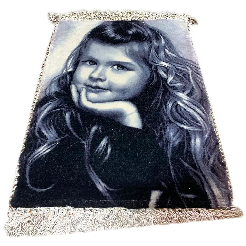 Picture rug with a photo of a girl, rectangular, with fringes along the edges.