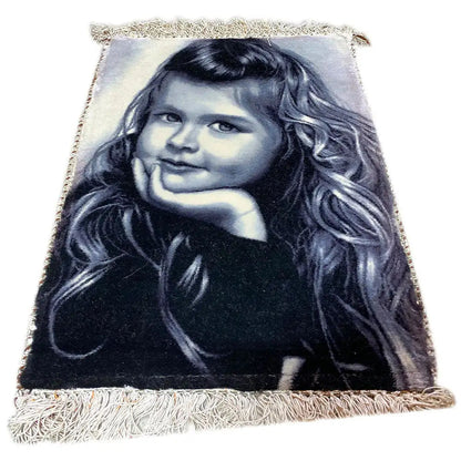 Picture rug with a photo of a girl, rectangular, with fringes along the edges.