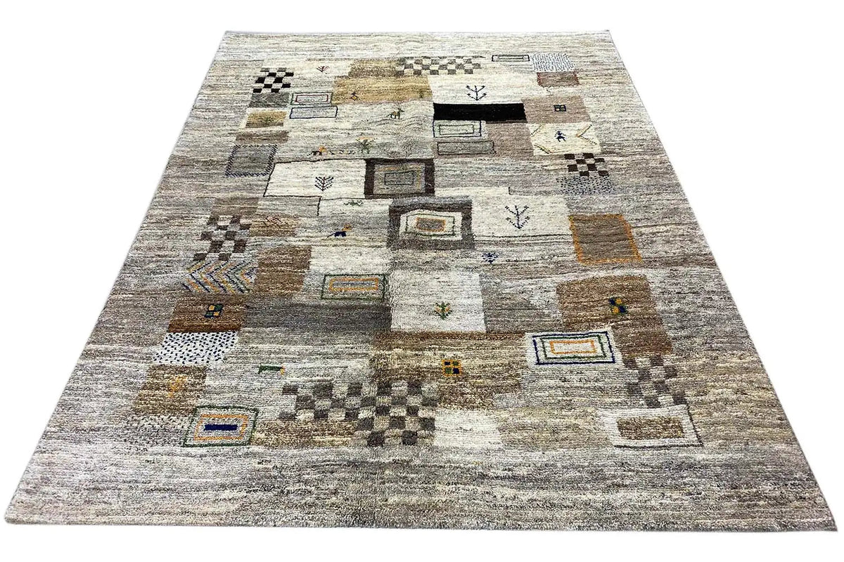 Gabbeh rug laid out flat: light gray design with patchwork squares and small ornaments