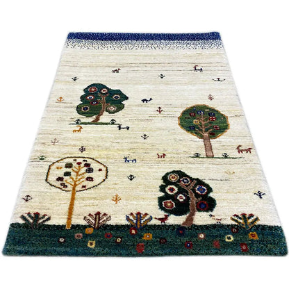 Gabbeh rug with a beige background, tree and animal motifs; dark green border and blue finishing band.