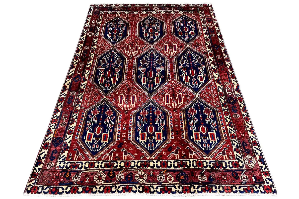 Oriental rug on a white background: red lattice pattern with a blue central field