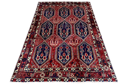 Oriental rug on a white background: red lattice pattern with a blue central field