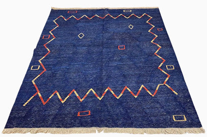 Qashqai kilim rug in oblique view, blue with a border pattern and fringes