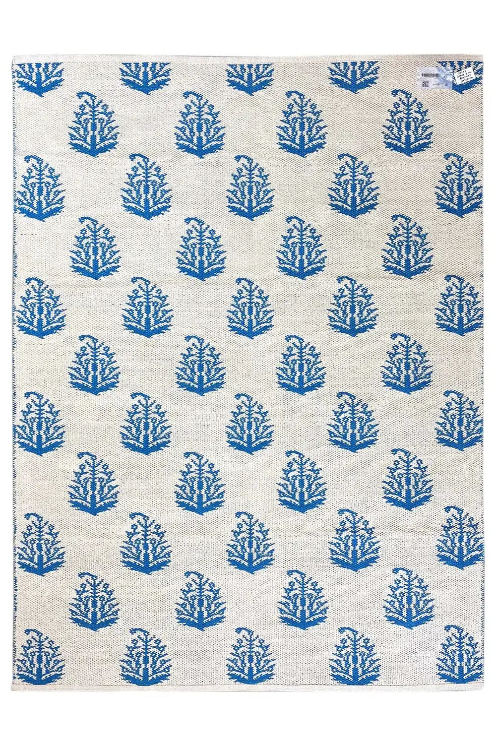 Cream-colored kilim with blue tree/branch motifs in an even all-over pattern.