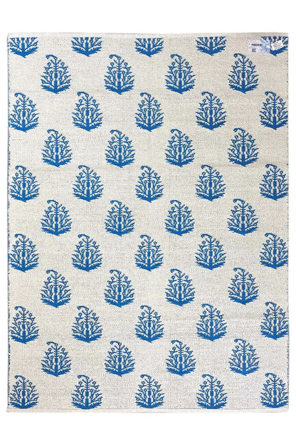 Cream-colored kilim with blue tree/branch motifs in an even all-over pattern.