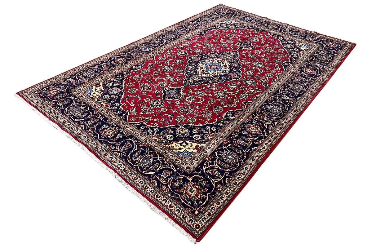 Keshan rug, rectangular: red center with a blue border, spread at an angle