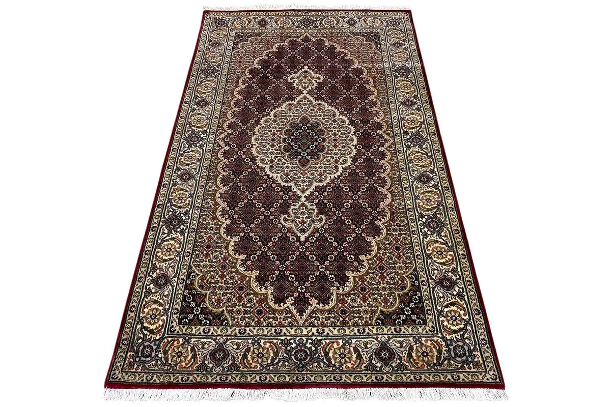 Indo-Tabriz rug: central medallion design with a dark field and border