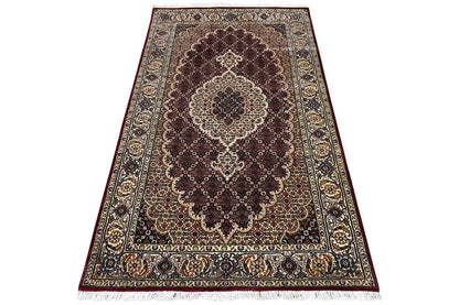 Indo-Tabriz rug: central medallion design with a dark field and border