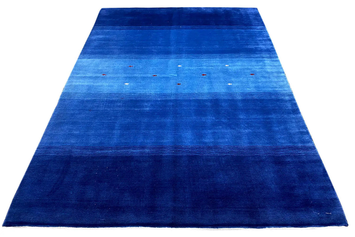 Blue rug with a narrow border, abstract color stripes, and colorful dots