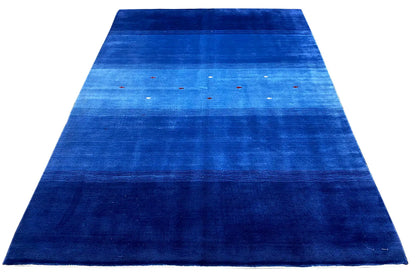 Blue rug with a narrow border, abstract color stripes, and colorful dots