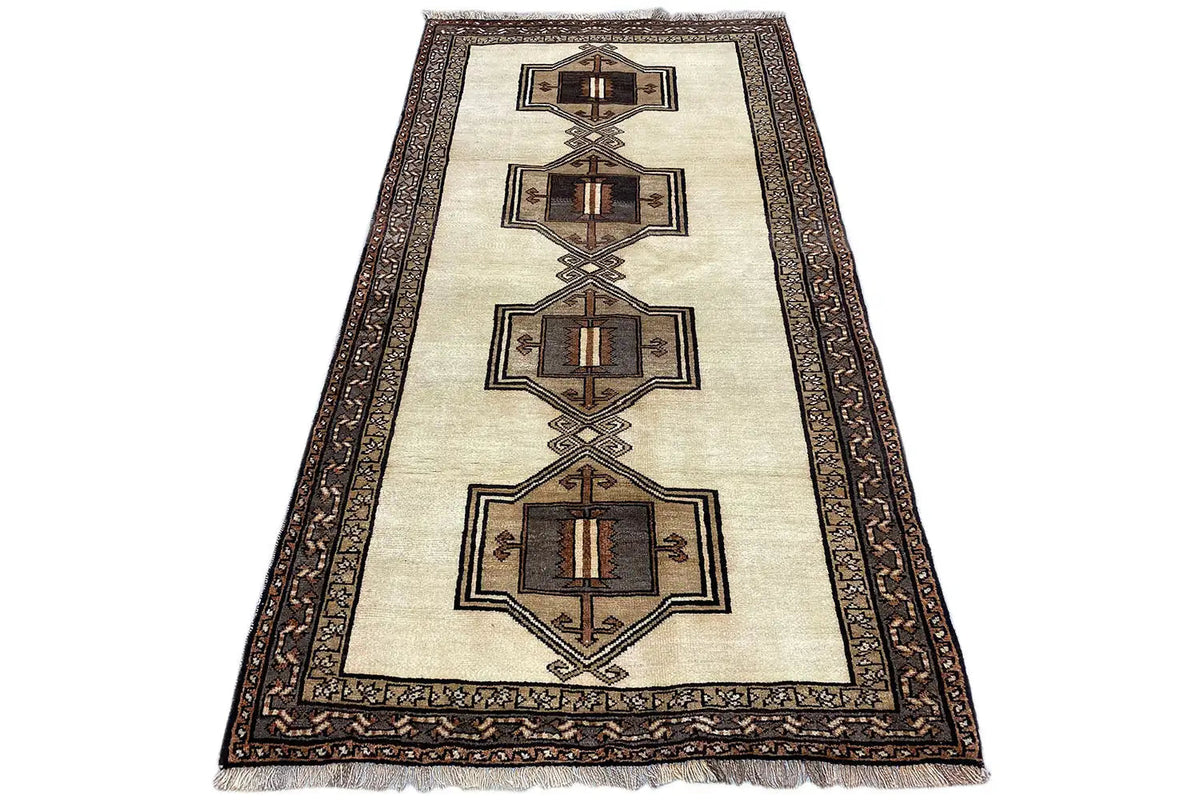 Oriental rug with a beige background, brown medallion pattern, and wide border.