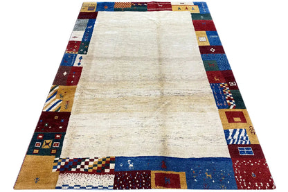 Gabbeh rug, rectangular: patchwork border and cream-colored center, viewed from above