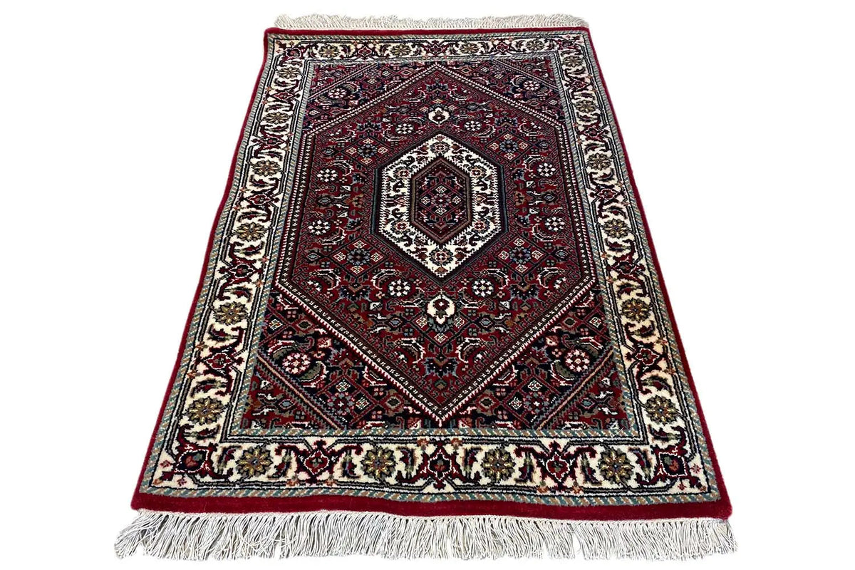 Carpet spread diagonally, red medallion pattern, cream border, fringes
