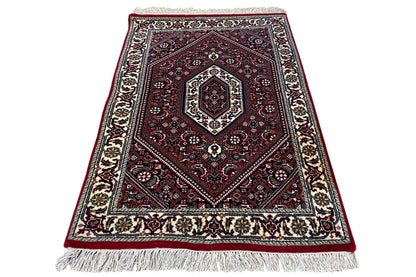 Carpet spread diagonally, red medallion pattern, cream border, fringes