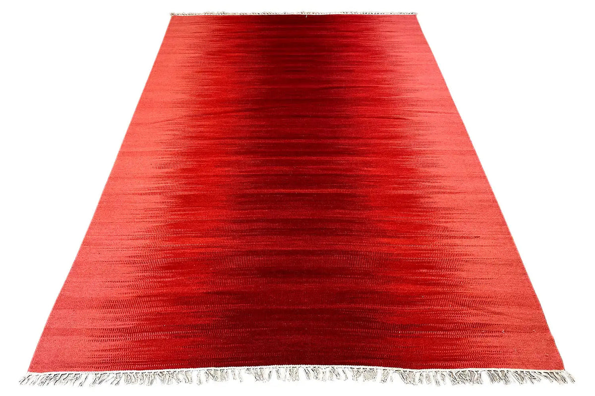 Red kilim rug in a wide view, edges with fringes