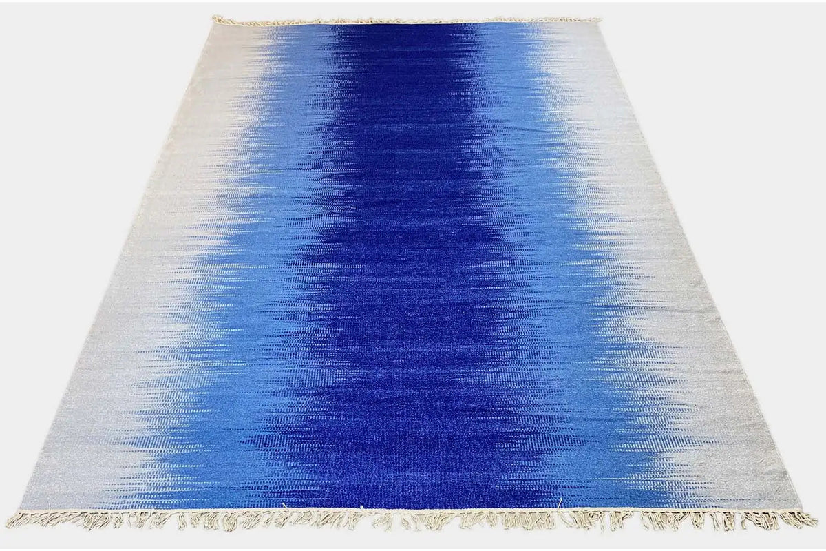 Kilim dhurrie rug with a color gradient from light beige to blue, finished with fringes