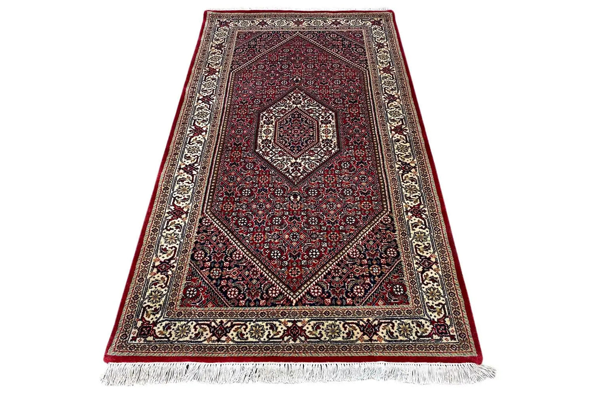 Rug 165x92 cm with a burgundy ornamental pattern and fringe along the bottom edge.