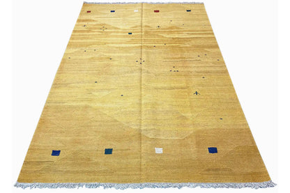 Ochre kilim rug with colorful small squares and wide fringes along the edge