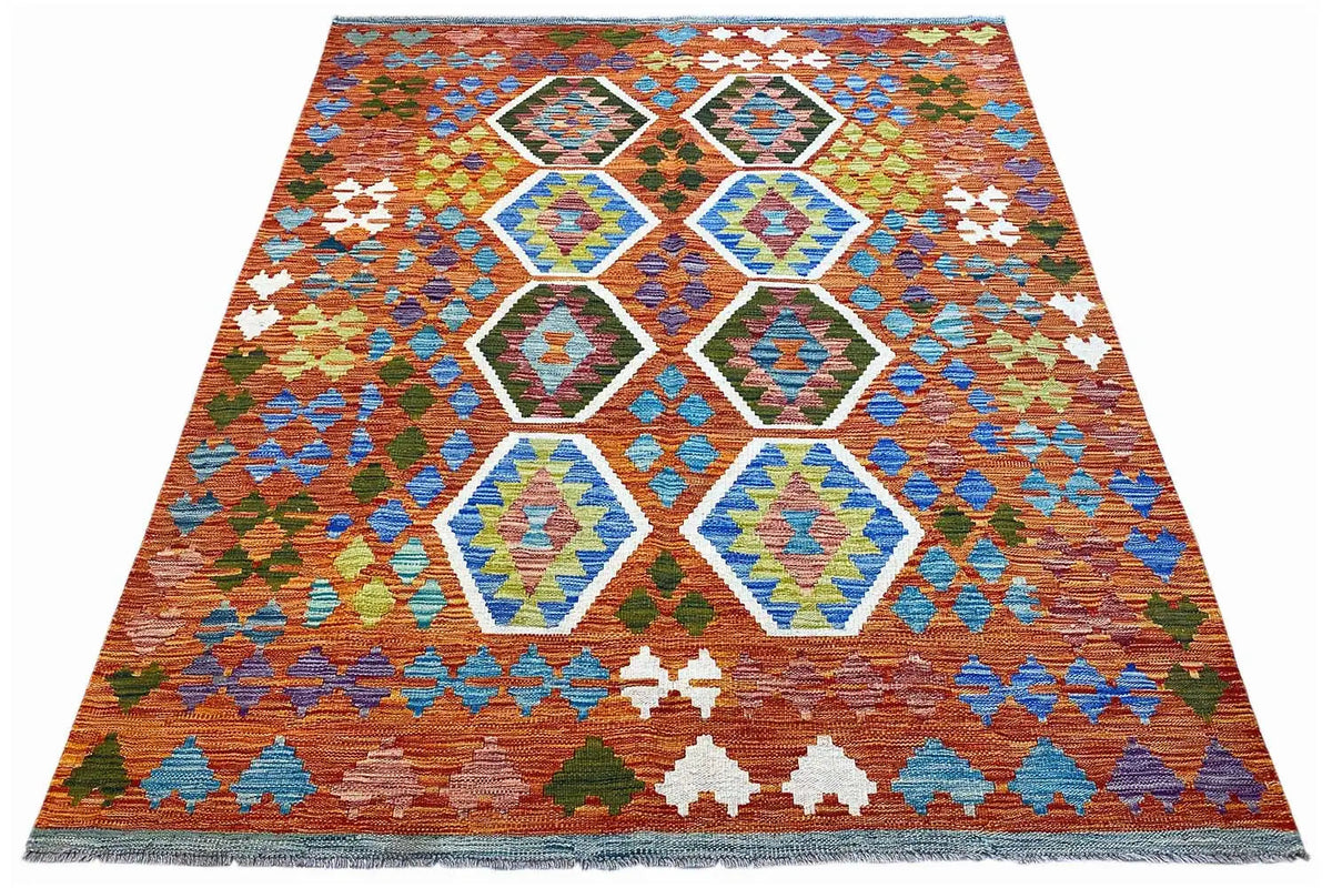 Colorful kilim with hexagonal ornaments and a zigzag border in orange, blue, and green