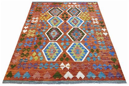 Colorful kilim with hexagonal ornaments and a zigzag border in orange, blue, and green