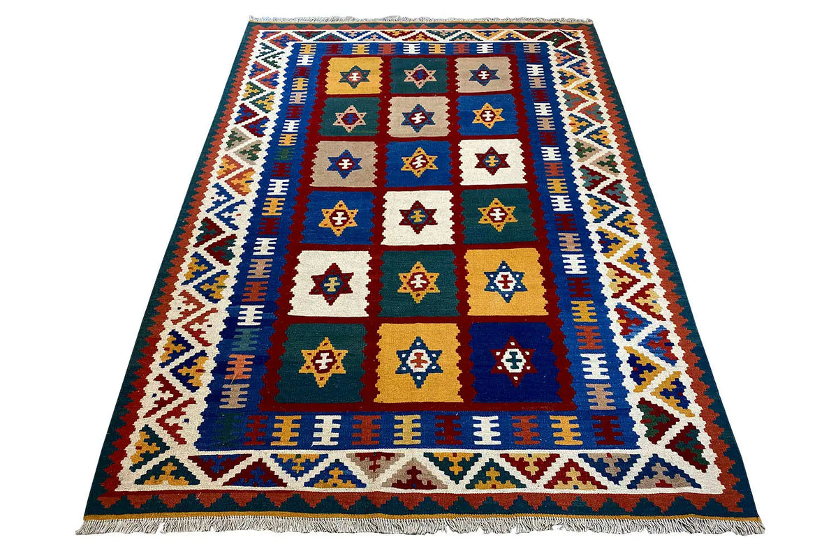 Qashqai kilim rug with a central diamond field, blue-and-white decorative border, and fringes