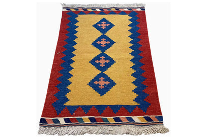 Red and blue kilim rug with a yellow central band, geometric diamonds, and fringes