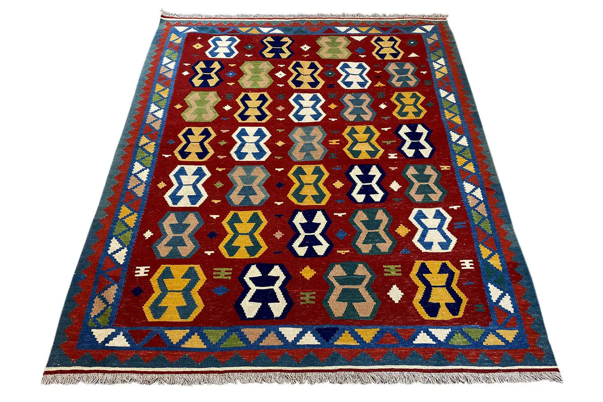 Kilim rug with a symmetrical small-scale pattern, red background, and blue-yellow accents