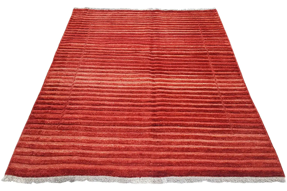 Red rug with a striped pattern and fringe along the bottom edge