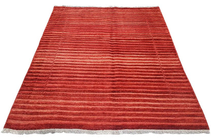 Red rug with a striped pattern and fringe along the bottom edge