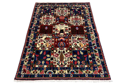 Rectangular rug with a dark background and beige and red tile pattern.