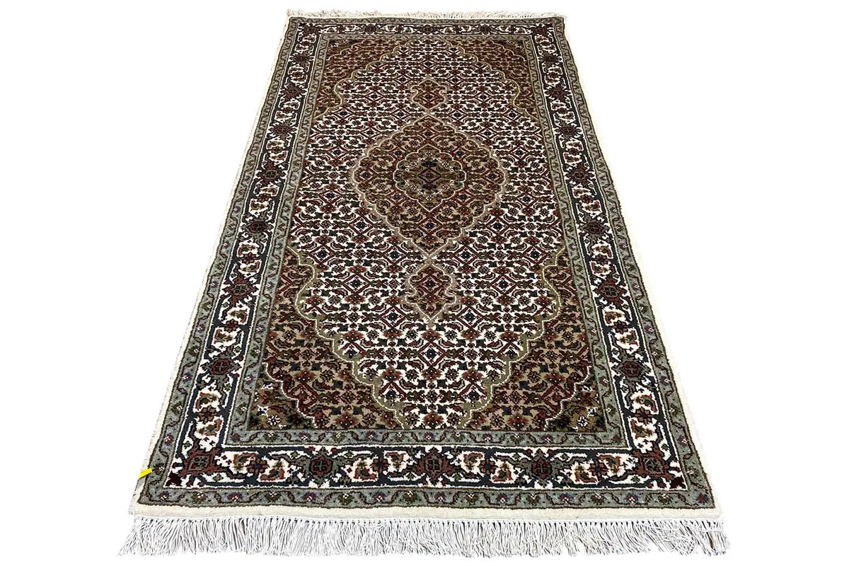 Tabriz rug with medallion pattern, bordered, rectangular, fringes along the edges