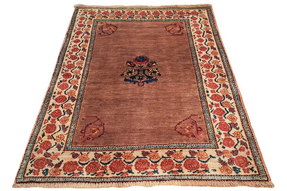 Brown oriental rug with medallion pattern, red ornamental border, and edging