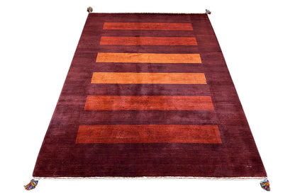 Gabbeh rug in dark red with wide orange horizontal stripes and tassels