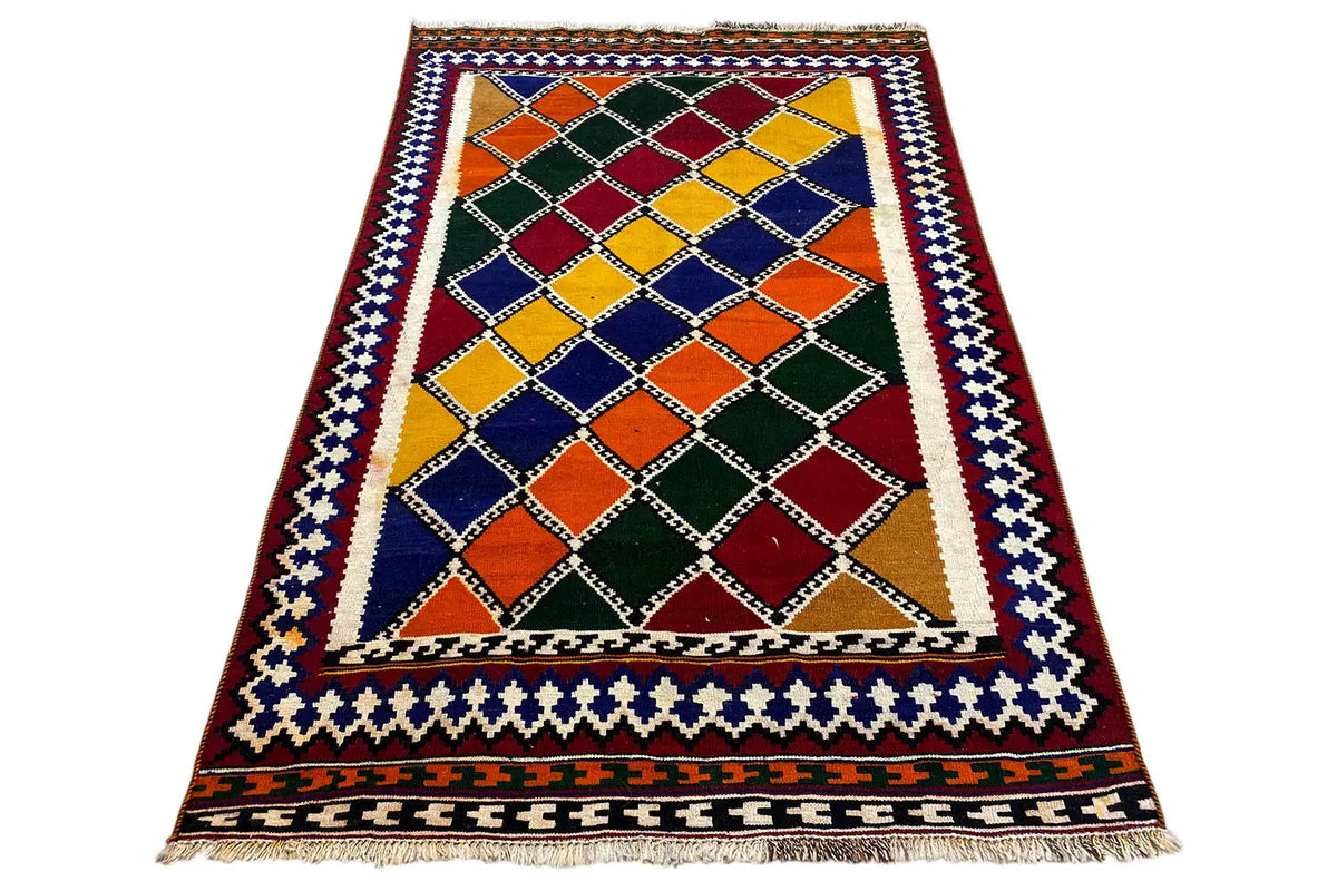 Rectangular kilim rug with a diamond grid, border trim, and multicolored surface